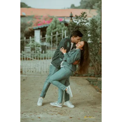 A fun and spontaneous moment as a couple in matching denim outfits shares a playful dip. This candid shot is full of energy and genuine affection.