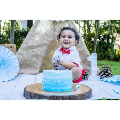 The pure delight of a first birthday cake smash. Little Ayansh is all smiles, covered in blue frosting during his outdoor milestone session. I love capturing these messy, happy moments.