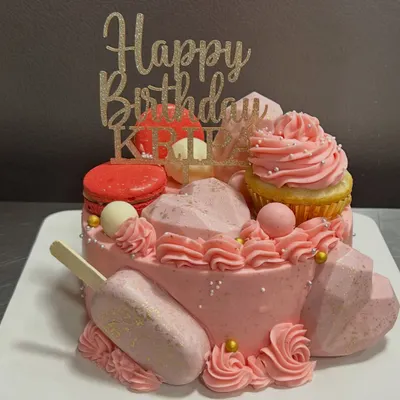This cake is a party in itself! I went all out with pink frosting, a cakesicle, macarons, and geometric hearts for a truly extravagant birthday celebration.
