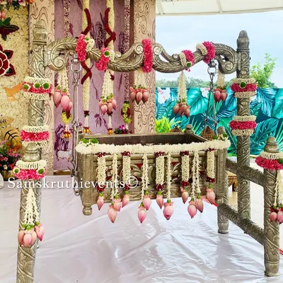 A beautifully decorated silver cradle for a naming ceremony. We've used delicate garlands of jasmine and pink lotus buds to create an elegant and pure look, making the 'Thottilu' a perfect centerpiece.