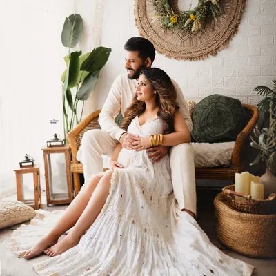 A picture of pure bliss in my favorite boho setup. This couple is surrounded by natural textures and warm light, creating a serene and romantic maternity portrait.