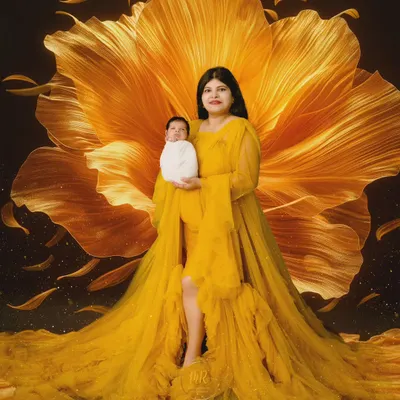 A breathtaking fine-art portrait of a mother and her newborn. I used a dramatic yellow gown and a large floral backdrop to create this vibrant and artistic image.