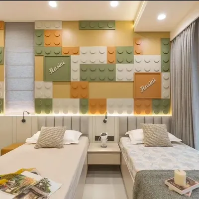 A dream room for any Lego enthusiast! This bedroom features a custom-built wall with colorful, oversized Lego blocks, creating a playful and interactive backdrop for two single beds.