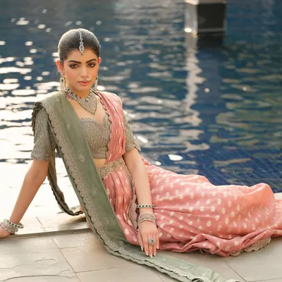 The dual-toned Jayanti Reddy saree is styled with a simple drape that allows the colors to stand out. The fabric is elegantly draped by the poolside, creating a serene and sophisticated image.