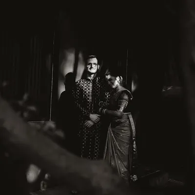 A dramatic black and white portrait of a couple, the shadows and light creating a timeless, artistic feel.