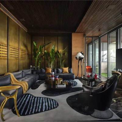 This lounge area is designed to feel grand yet simple, airy yet cozy. The design uses a calm, earthy color palette with brass wall panels, a custom-shaped rug, and plush leather sofas to create a sophisticated space for relaxation and socializing.
