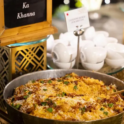 Our 'Dilli-6 Ka Khanna' station, featuring a large pan of aromatic biryani. This counter is a tribute to the legendary street food of Old Delhi, bringing those timeless flavors to your luxury event.