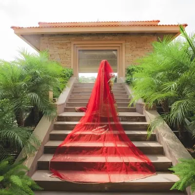 A dramatic bridal entry shot, with the long red veil cascading down the steps. I help stage these iconic photos that capture the grandeur of the bride's arrival.