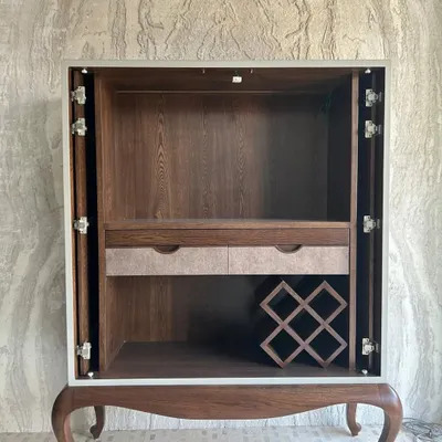 The concealed bar cabinet, shown here with its pocket doors fully retracted. The interior is crafted from warm wood veneer and features a built-in wine rack, drawers, and a pull-out counter, demonstrating our commitment to maximizing functionality within a compact footprint.