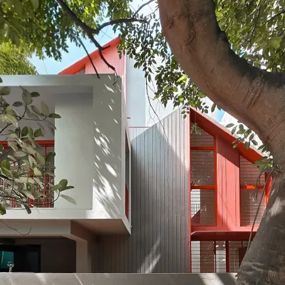 This was a renovation project for a returning client. We added bold red accents to the facade to give the home a fresh, modern identity while carefully working around the beautiful, mature trees on the property.