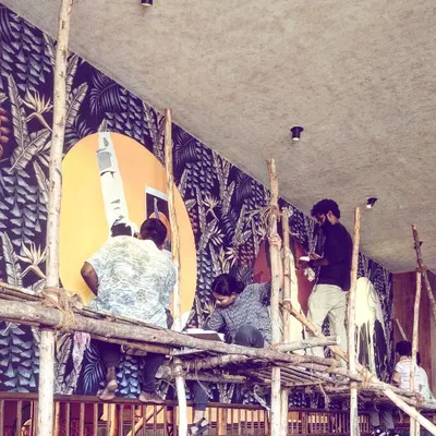 The team high up on scaffolding, working on a massive tropical-themed mural. This shot captures the scale of our projects and the collaborative effort required to bring these huge walls to life.