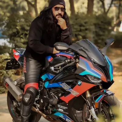 A powerful portrait of a rider with his BMW superbike. The low angle and the model's intense gaze create a look that is all about beauty and beast.