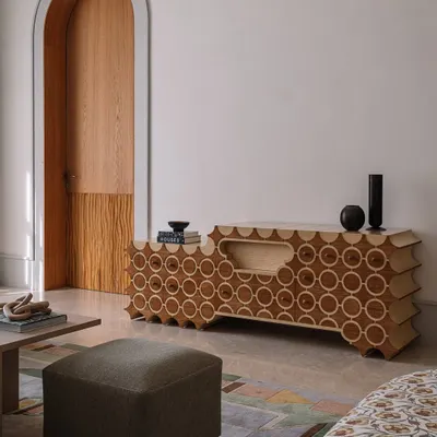 This is 'Brutus,' our handcrafted TV unit. The design features a repeating circular pattern inlaid into the wood, with a unique scalloped profile. It’s a piece that hides technology behind a beautiful, sculptural facade.