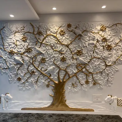 The completed Kalpavriksh mural in a corporate office. The white and gold tree is flanked by two small cow sculptures, adding to the symbolism of prosperity and abundance.