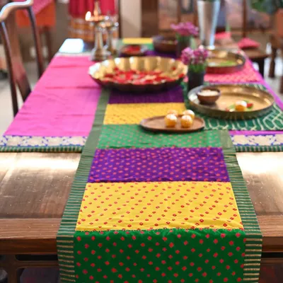 A custom-made festive set featuring a vibrant patchwork Bandhani runner on a dining table. The set was designed to create a colorful and celebratory tablescape for Diwali.