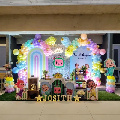 A full view of a vibrant Cocomelon themed birthday party. I used a pastel rainbow balloon arch and character cutouts to create a cheerful atmosphere.