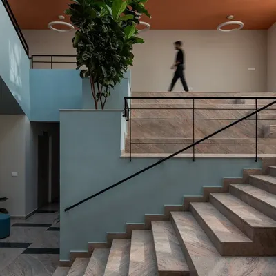 The main staircase of the Nirbhaya Centre in Bangalore, a government facility for women and children. We used wide, welcoming steps, soothing colors, and indoor planters to create a space that feels safe, approachable, and non-institutional.