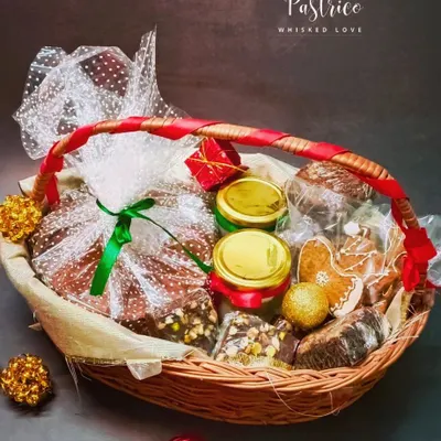 My signature Christmas hamper, thoughtfully curated and wrapped with a festive ribbon. It’s the perfect gift, filled with a variety of my best holiday treats like plum cake, brownies, and fudge.