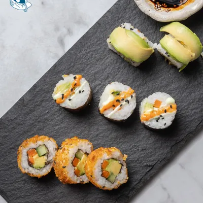 A platter of assorted sushi, including crispy tempura rolls and creamy avocado rolls. We bring the art of Japanese cuisine to your event.