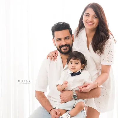 A picture-perfect family of three. Dressed in coordinating white outfits, this family portrait is bright, airy, and full of love.