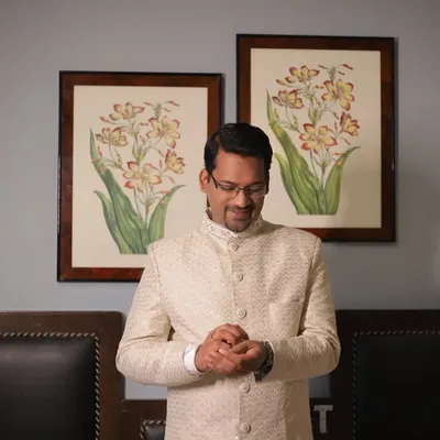 A quiet moment with the groom as he gets ready, adjusting his attire. This portrait captures his calm and anticipation.