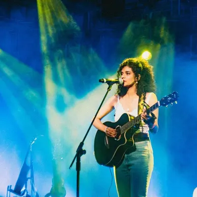 This is me in my element, on stage with my guitar under the lights. I love performing live, and this experience opening for a major indie band shows my professionalism and ability to connect with a large crowd.