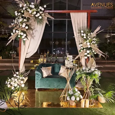 This luxurious outdoor seating arrangement, complete with a velvet couch and elaborate floral displays, demonstrates our ability to create stunning, photo-ready settings for high-end events like weddings and receptions.