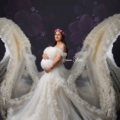 A mother is an angel on earth. This portrait uses a magnificent white ruffled gown with flowing wings to create a truly ethereal and angelic image of the mother-to-be.