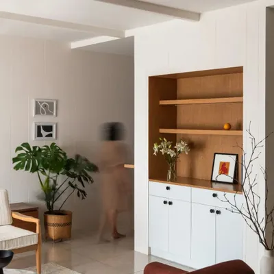 The foyer and living area of Chakma's Home, an apartment interior project. We used a simple palette of white and wood, with clean lines and thoughtful storage to create a calm and uncluttered space.