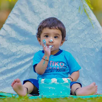 The first taste of birthday cake! This little one is getting right into his outdoor cake smash session, set against a simple teepee backdrop for a natural, fun feel.