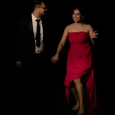 For this pre-wedding shoot, I styled the couple in a classic, high-contrast look. Her custom red dress with an asymmetrical hem brings a pop of color and movement against his sharp, dark suit.
