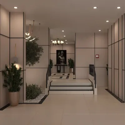 A view of the lobby showing the blend of modern paneling, greenery, and classical art. The mirror reflects the elegant chandelier, adding depth to the space.