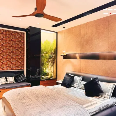 This bedroom is a perfect example of creating a warm, earthy retreat. The design features a leather-upholstered bed, textured wall panels, and a cozy window seat that brings in natural elements.
