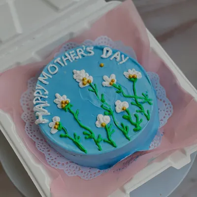 A beautiful blue bento cake for Mother's Day, hand-painted with delicate white flowers. These mini cakes are perfect for showing someone you care.