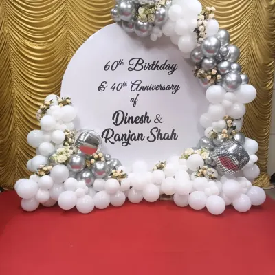 A special backdrop for a double celebration: a 60th birthday and a 40th anniversary. I used a classic white and silver balloon arch with the couple's names, Dinesh and Ranjan Shah.