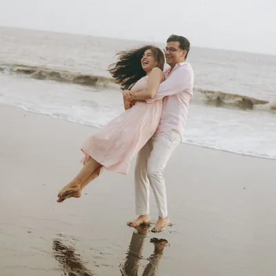 A moment of pure, carefree joy. I asked him to lift her, and the resulting laughter and movement against the ocean backdrop created this beautiful, spontaneous portrait of Ritu and Tarush.