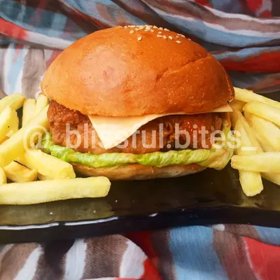 My homemade Chicken Zinger Burger is a complete meal, featuring a perfectly fried chicken patty with cheese and lettuce, plated with crispy fries.