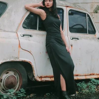 A solo portrait session with a vintage Ambassador car. The rustic setting and the model's confident pose create a timeless, powerful image.