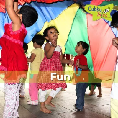 The parachute game is a perfect activity for promoting teamwork and gross motor skills. The children's faces light up with excitement as they work together to make colorful waves, learning to cooperate in the most joyful way.