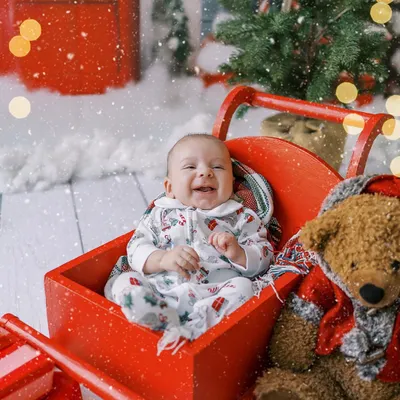 A baby's first Christmas is pure magic. This little one's happy laugh in a festive red sleigh creates a memory that will be treasured for years to come.
