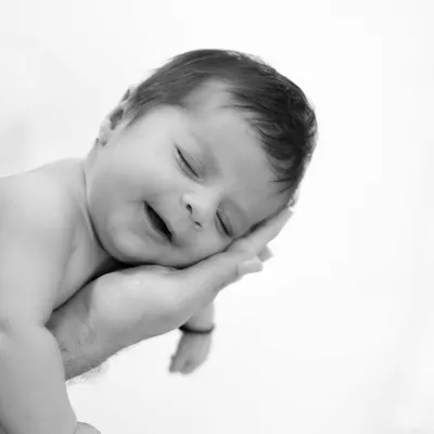 So small, so loved. This classic black and white photo of a newborn resting in their parent's hand is a powerful reminder of how tiny they once were.