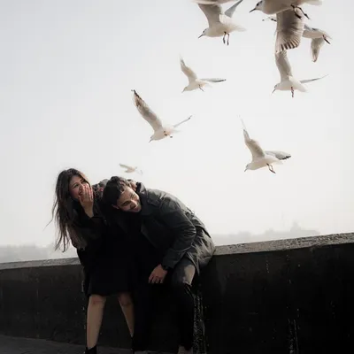 A moment of spontaneous laughter on a Mumbai sea face, with seagulls taking flight around them. This image feels like a lucky, magical accident, perfectly capturing the city's unpredictable beauty.