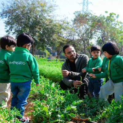 A teacher shows a group of young students a fresh green bean from the plant. These interactive lessons help children understand exactly where their food comes from.