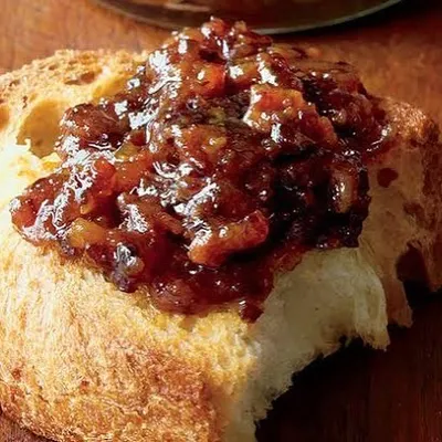 My homemade Bacon Jam spread generously on a slice of crusty bread. It's a sweet, savoury, and smoky condiment that is perfect with breakfast, burgers, or cheese boards.