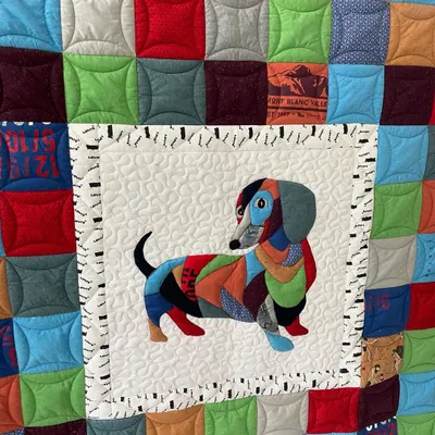 A close-up of the dachshund memory quilt, detailing the intricate appliqué work and the variety of t-shirt fabrics used.