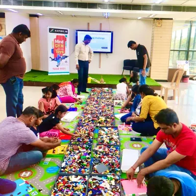 A fantastic overhead view of our LEGO Mindgym workshop. You can see the huge spread of bricks and families working together on their creations, showing the scale and engagement of the event.