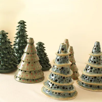 A forest of my handmade ceramic Christmas tree candle holders. I offer them in different styles and glazes, from leafy green coniferous trees to whimsical, perforated designs.