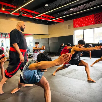 Correct form is everything. Here, I am observing a student executing a lunge, a key movement for developing flexibility and power. We provide constant, hands-on guidance to ensure every posture is performed safely and effectively for maximum benefit.