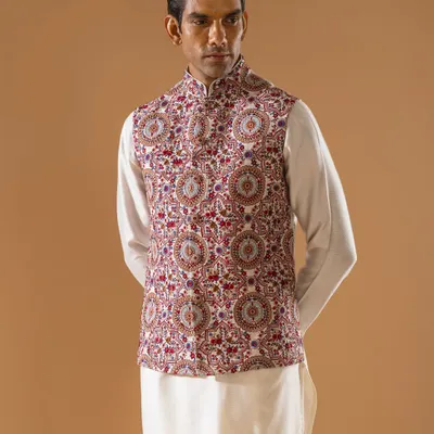 This Jawahar jacket is a masterpiece of dense, multi-colored embroidery, creating a rich tapestry of traditional motifs. Paired with a simple white kurta, it is a statement piece that speaks of heritage and artistry.