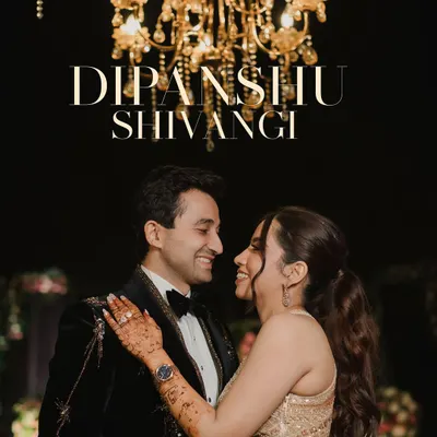 A romantic portrait of the couple sharing a smile under a grand golden chandelier. This shot captures the elegance of their sangeet night, highlighting their chemistry and the luxurious ambiance.